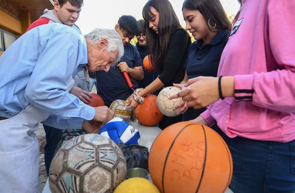 Andrés Rosatto, hermano de la congregación hermanos maristas, enseña a reparar pelotas a chicos de la escuela Santa María de Belén de Las Heras. | Foto: Marcelo Rolland / Los Andes