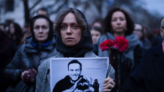 Una mujer sostiene flores y un retrato del destacado opositor ruso Alexei Navalny durante una protesta frente a la embajada rusa en Berlín, Alemania, el viernes 16 de febrero de 2024, tras la noticia de su muerte estando en prisión en Rusia. (Foto AP/Markus Schreiber)