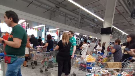 La gente comprando en los supermerados atestados.