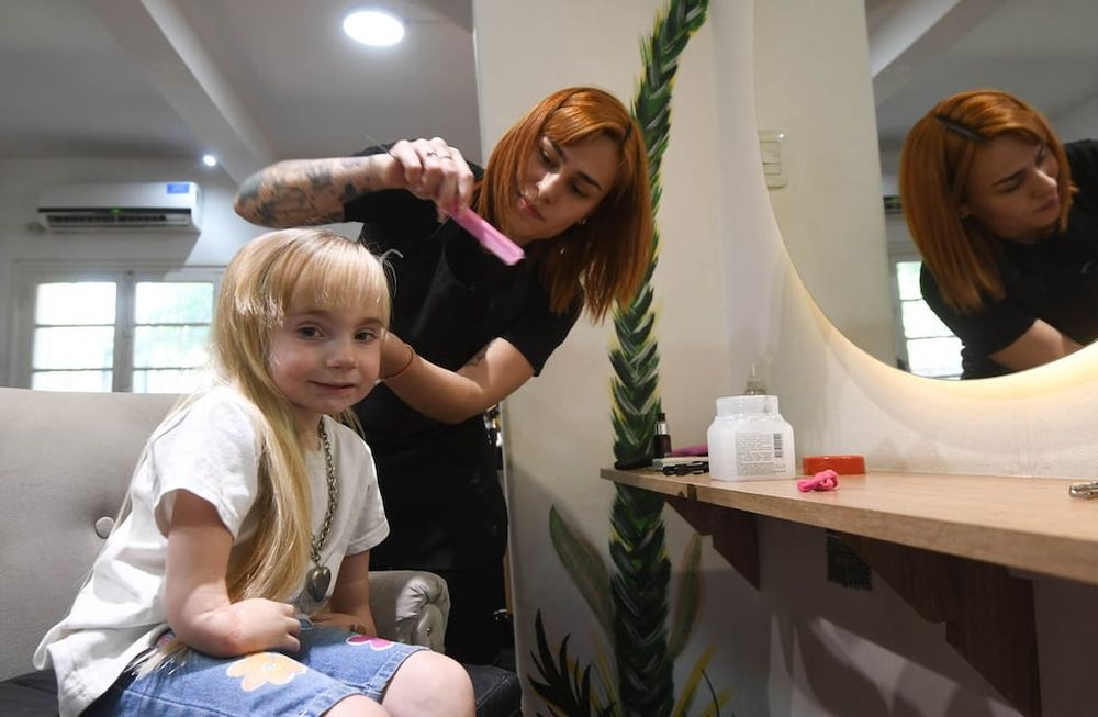 Campaña de corte solidario para juntar dinero para ayudar a Juanita, la nena que tienen que realizarle una operación en sus manos.Sol le hace las trensas a Juanita Foto: José Gutierrez / Los Andes