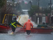 Pescadores del sector Cerro Verde Bajo, en Penco (Chile), intentan rescatar sus botes que son arrastrados por el agua que ingresó por las marejadas