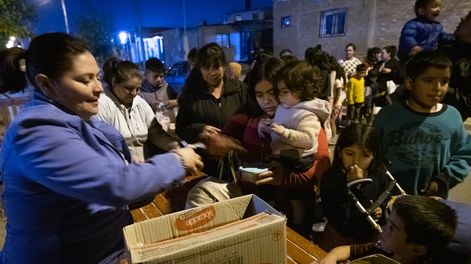 Noche fría en El Algarrobal, Las Heras: Conurbano mendocino.  El país vive una de sus peores crisis económicas contemporáneas y se refleja directamente en el aumento de la gente que concurre a los comedores comunitarios para completar algunas de las cuatro comidas diarias. Allí es donde los números de la pobreza e indigencia adquieren un rostro.  El comedor y merendero Los Horneritos da raciones de comida todos los martes y jueves a más de 1500 personas entre niños, adultos y ancianos.Gabriela Carmona entregando raciones en la puerta del comedor comunitario.Foto: Ignacio Blanco / Los Andes
