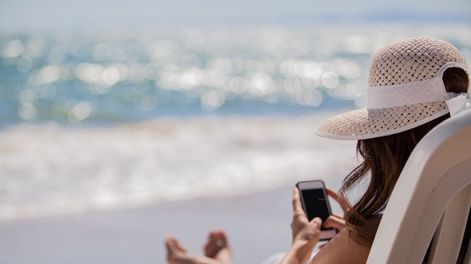 En otra cosa, la mujer frente al mar pero sumergida en su celular.