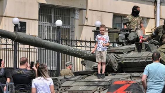Un niño es fotografiado por sus padres sobre un tanque del Grupo Wagner en las calles de Rostov, en Rusia.
