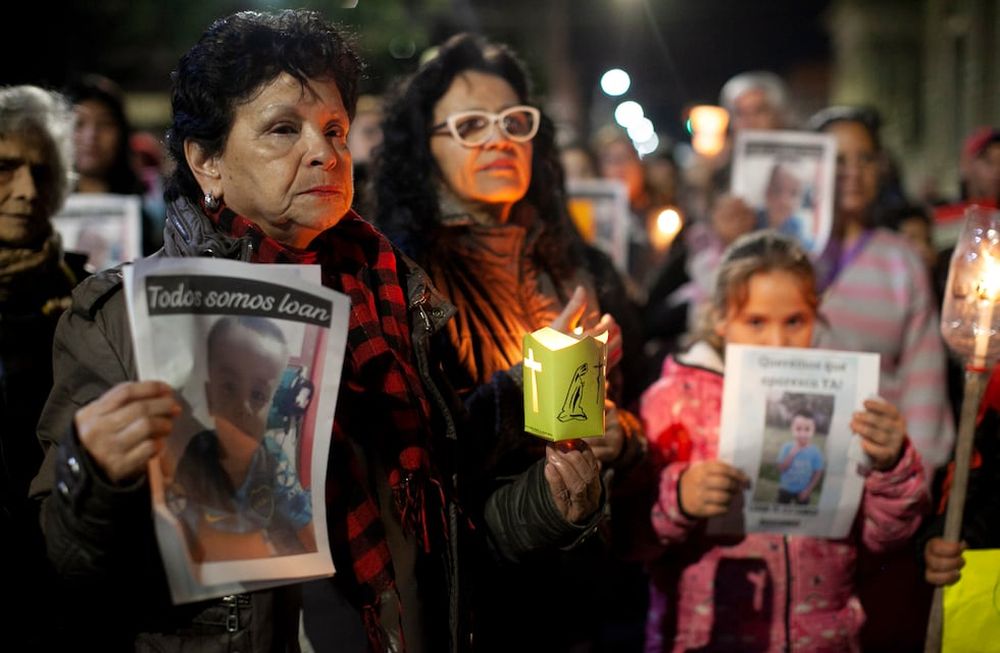 Manifestantes sostienen fotografías del niño Loan Danilo Peña el lunes 24 de junio de 2024, en Corrientes, Argentina.