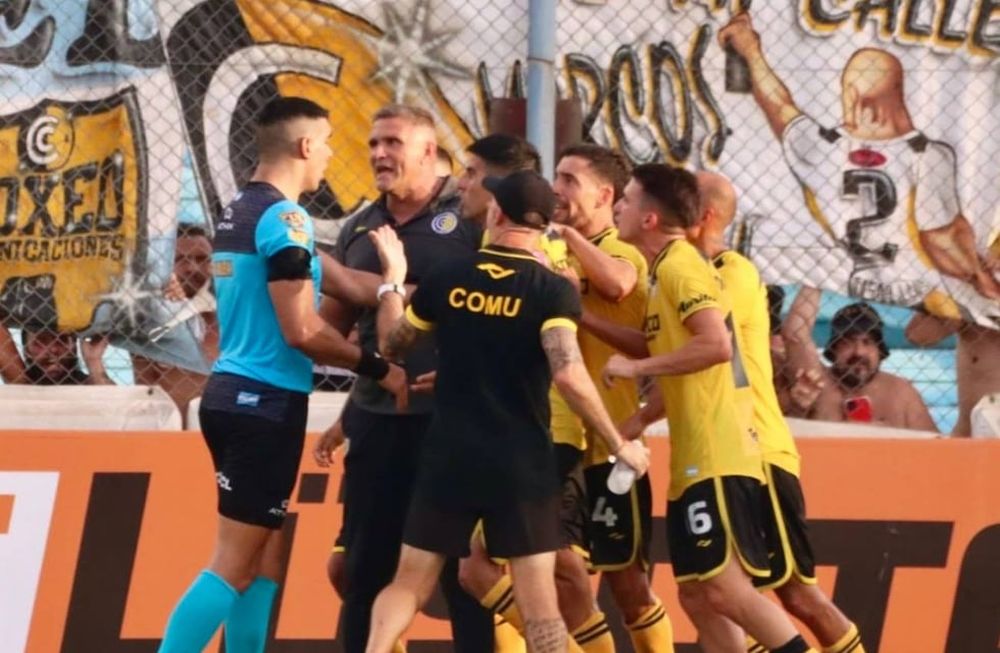 La bronca de los jugadores de Comunicaciones contra el árbitro Joaquín Gil, quien cobró un penal inexistente en el último minuto del partido en favor de Riestra (Prensa Comunicaciones).