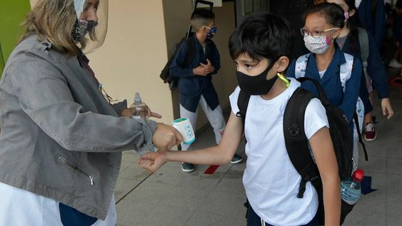 En fila. Los docentes recibieron, en las puertas de las escuelas, a sus alumnos. Antes de ingresar, les tomaron la temperatura y les rociaron alcohol en sus manos. Foto: Orlando Pelichotti / Los Andes