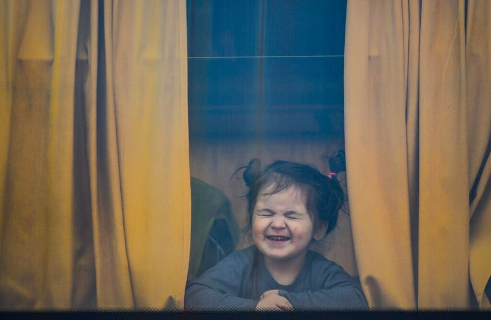 Foto ilustrativa de una niña que sonríe a pesar de que lo que lo rodea no es lo mejor.