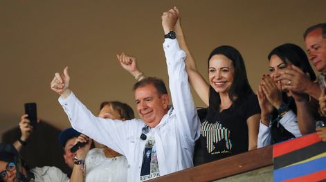 El candidato presidencial de la oposición venezolana Edmundo González, izquierda, y la líder opositora María Corina Machado levantan los brazos durante una reunión con jóvenes en la Universidad Central de Venezuela (UCV) en Caracas, Venezuela, el domingo 14 de julio de 2024. (AP Foto/Cristian Hernández )