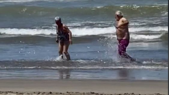 La pareja juega en el mar