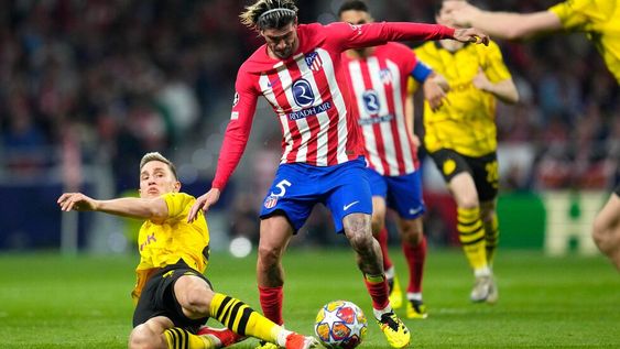 Rodrigo De Paul (centro) del Atlético del Madrid pugna por el balón con Nico Schlotterbeck del Borussia Dortmund en los cuartos de final de la Liga de Campeones, el miércoles 10 de abril de 2024, en Madrid.