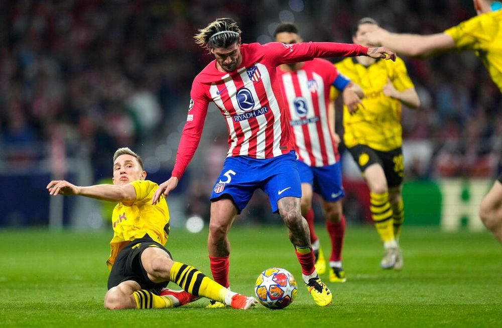 Rodrigo De Paul (centro) del Atlético del Madrid pugna por el balón con Nico Schlotterbeck del Borussia Dortmund en los cuartos de final de la Liga de Campeones, el miércoles 10 de abril de 2024, en Madrid.