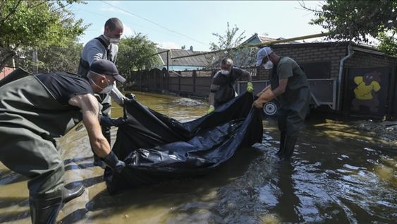 Equipos de rescate rusos trasladan un cadáver encontrado en una casa inundada luego de la destrucción de la represa de Nova Kajovka, en el óblast de Jersón.