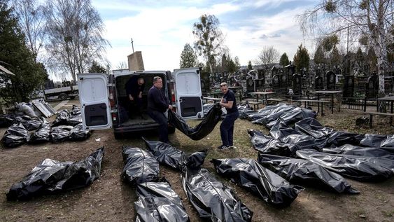 Trabajadores del cementerio descargan los cuerpos de los civiles asesinados desde una camioneta en el cementerio de Bucha, en las afueras de Kiev. (AP /Rodrigo Abd)