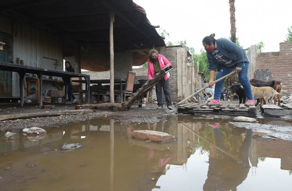 Inundados. Silvia y Ariadna, del merendero Corazones Felices, de El Sauce, Guaymallén, trabajan haciendo canaletas para que  corra el agua en el lugar donde comen los niños almuerzan. Foto: José Gutiérrez / Los Andes.