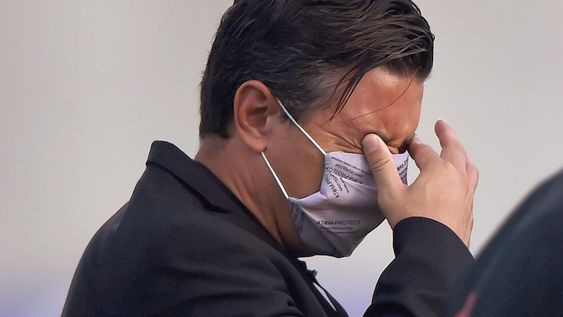 El DT. Marcelo Gallardo se tapa los ojos, afectado por los gases lacrimógenos que llegaron al estadio en el que se jugaba Junior de Barranquila ante River. (AP)