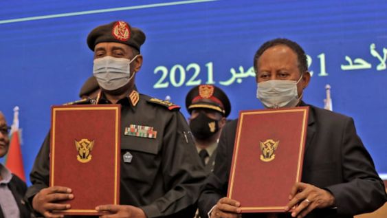 El principal general de Sudán, Abdel Fattah al-Burhan (izq.), Y el primer ministro Abdalla Hamdok levantan documentos durante una ceremonia de firma de acuerdos el 21 de noviembre. - AFP