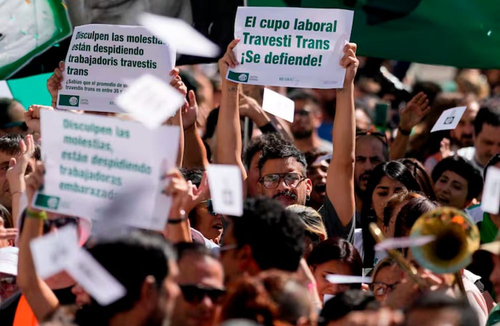 Ariel Heredia, que se identifica como no binario, muestra un cartel a favor del cupo laboral trans en una manifestación que reclama la reincorporación de empleados públicos despedidos, a las afueras del Ministerio de Economía en Buenos Aires. Foto: La Nación