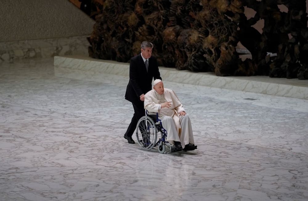 El Papa Francisco llega en silla de ruedas para asistir a una audiencia con monjas y superiores religiosos en el Aula Pablo VI en el Vaticano. / Foto: AP