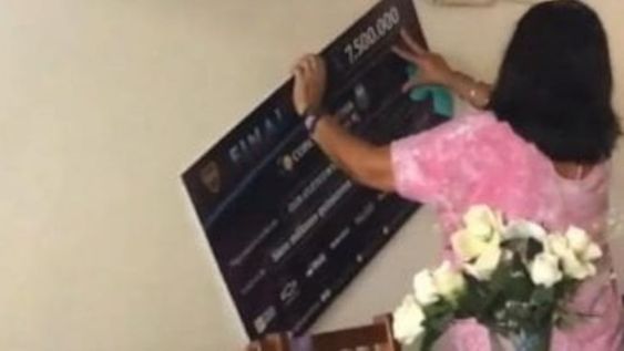 La mamá de Marcos Rojo con el cheque de la Copa Argentina en el living de su casa. / Gentileza.