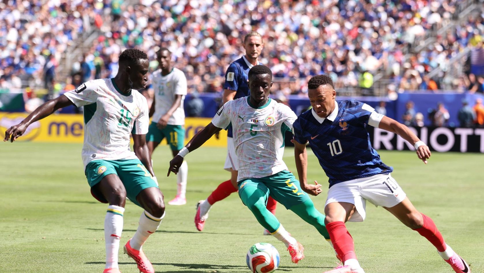 Kylian Mbappé, autor del primer gol de Francia, busca eludir las marcas de Idrissa Gueye y Krépin Diatta de Senegal.&nbsp;