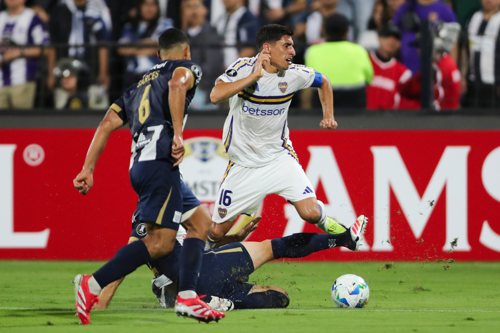 Guillermo Enrique (abajo) de Alianza disputa el balón con Miguel Merentiel (d) de Boca este martes, en un partido de la segunda ronda de la Copa Libertadores entre Alianza Lima y Boca Juniors en el estadio Alejandro Villanueva en Lima (Perú). EFE/ Paolo Aguilar