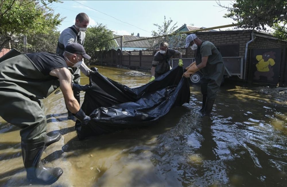 Equipos de rescate rusos trasladan un cadáver encontrado en una casa inundada luego de la destrucción de la represa de Nova Kajovka, en el óblast de Jersón.