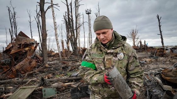 Un militar del Ministerio del Interior recoge proyectiles sin explotar, granadas, minas, después de las recientes batallas en Hostomel cerca de Kiev. (AP/Efrem Lukatsky)
