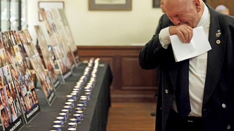 Un hombre observa carteles con imágenes de víctimas mientras asiste a una ceremonia oficial de conmemoración en la Gran Sinagoga de Bruselas. (AP)
