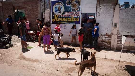 Las familias del asentamiento esperan bajo un intenso calor que les entreguen el bolson con alimentos.La Universidad Catolica Argentina dio a conocer la cifra de la porbreza en Argentina es el 44,2%.