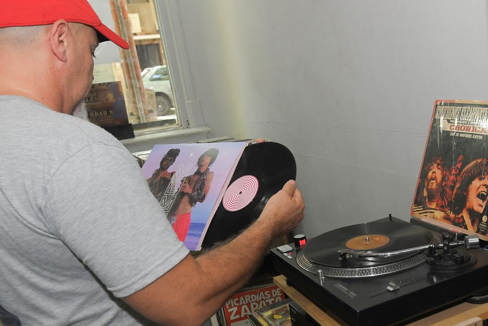 Furor por los vinilos, crece la cantidad de gente que compra y colecciona discos. Gastón Arro de Mellon Collie discos ordena los vinilos en su local. Foto: Marcelo Rolland / Los Andes