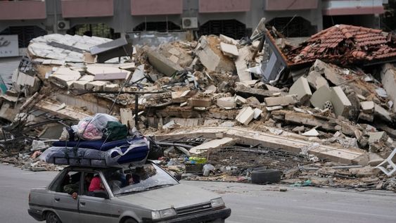 Residentes desplazados conducen entre escombros de edificios destruidos mientras regresan a sus aldeas, tras un alto el fuego entre Israel y Hezbollah que entró en vigor el miércoles 27 de noviembre de 2024 en Tiro, en el sur del Líbano. (AP Foto/Hussein Malla)