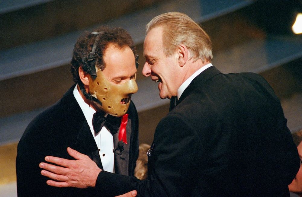 El maestro de ceremonias de los Oscar Billy Crystal luce la máscara de Hannibal Lecter y dialoga con Anthony Hopkins en la 64 ceremonia de los Premios Oscar, el 30 de1992 en Los Angeles (AP Photo/Craig Fujii)