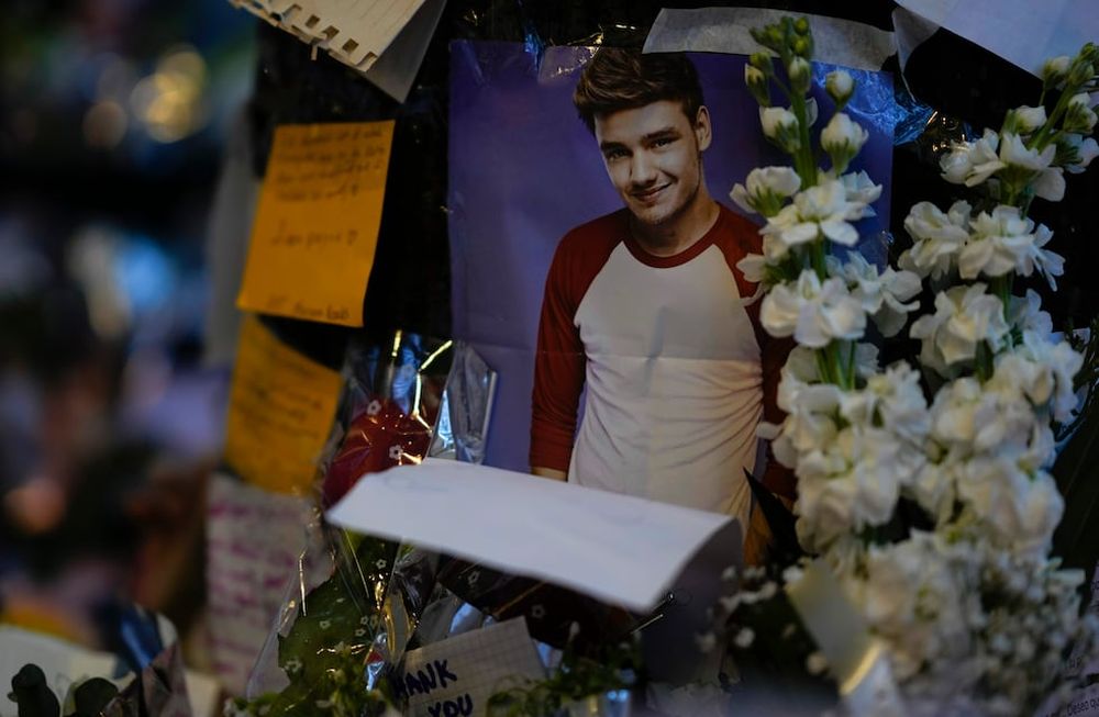Una foto del excantante de One Direction Liam Payne colocada en un altar improvisado fuera del hotel en el que fue hallado muerto tras caer de un balcón en Buenos Aires, Argentina, el jueves 17 de octubre de 2024. (AP Foto/Natacha Pisarenko)