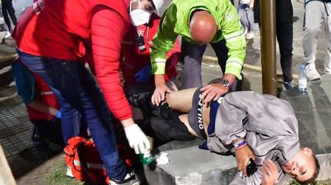 Miembros de Defensa Civil atienden a un herido en las inmediaciones del estadio de Gimnasia. / Gentileza: Clarín.