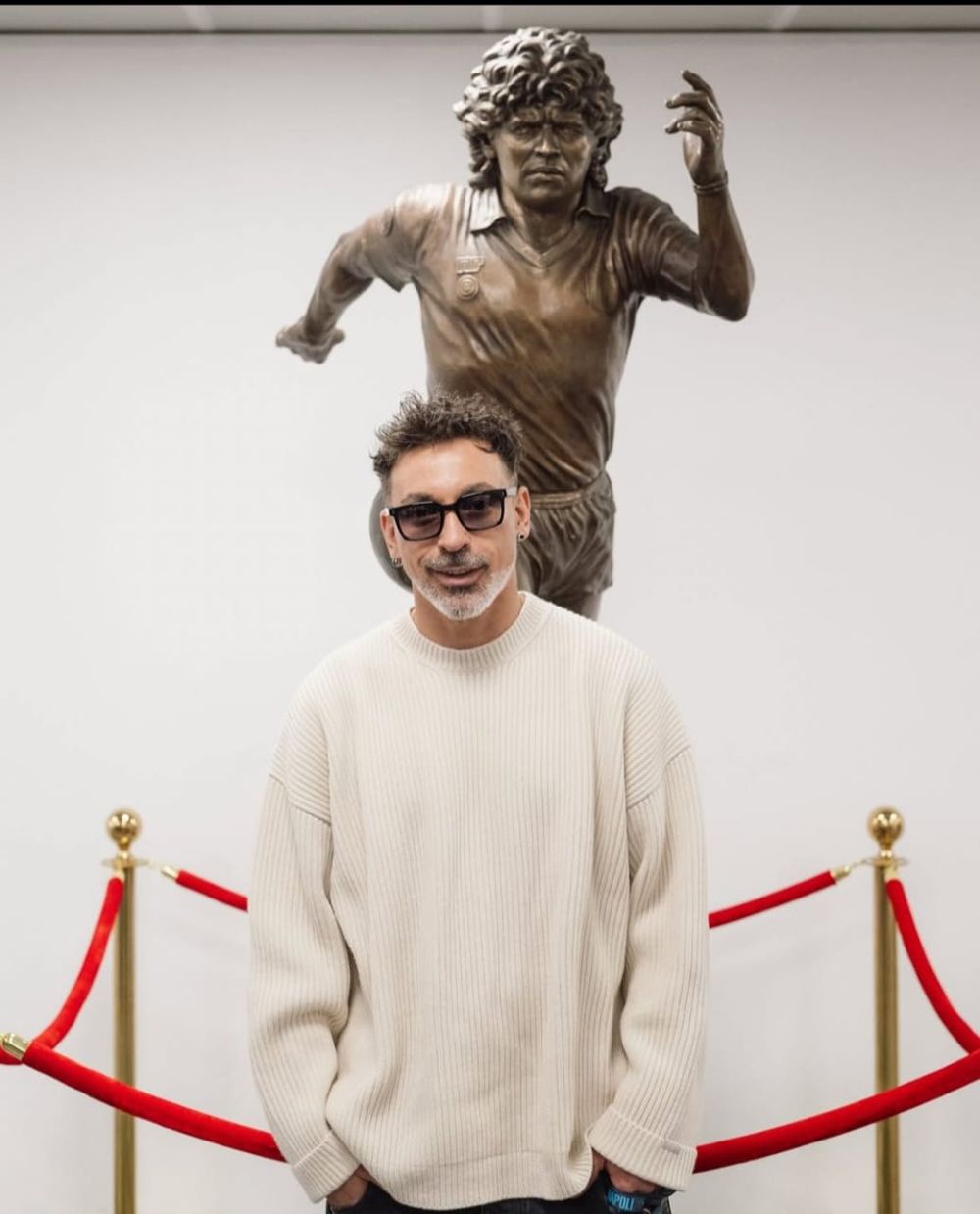 Pocho Lavezzi junto a la escultura de Diego Maradona, en Nápoles.