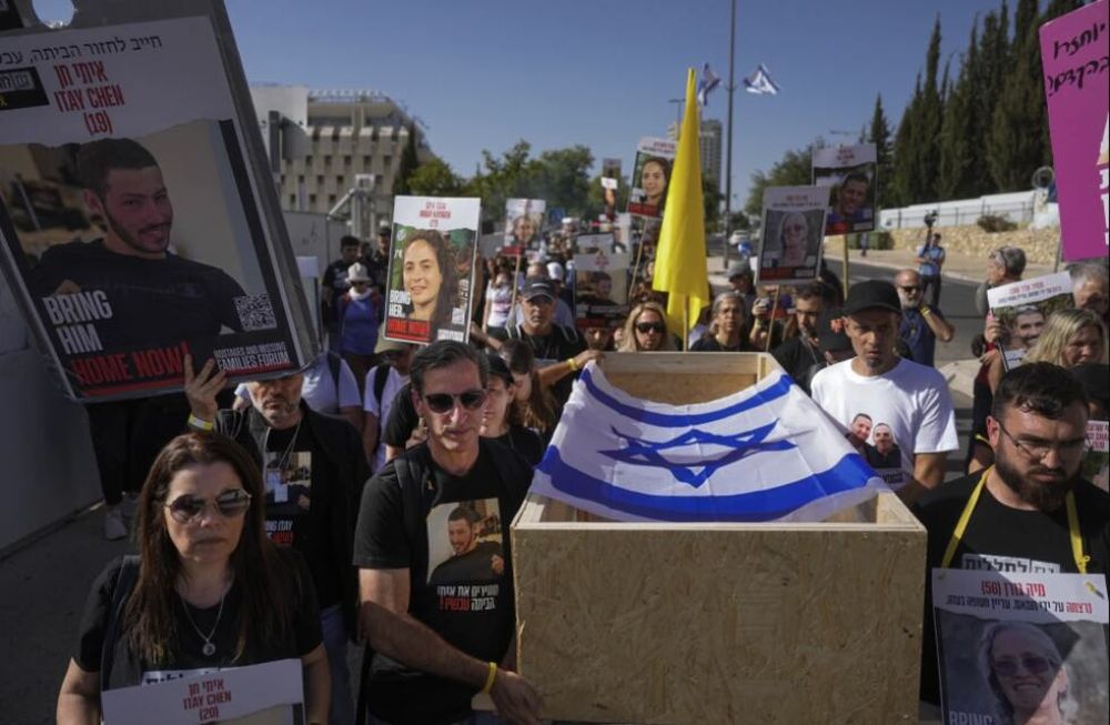 Hagit y Ruby Chen (izq) llevan un féretro vacío en simulacro de procesión fúnebre para israelíes cuyos restos están retenidos por el grupo palestino Hamás en la Franja de Gaza, cerca de la sede del Parlamento israelí, en Jerusalén, el 9 de mayo de 2024, en la previa al Día de los Caídos que recuerda a los soldados muertos en la guerra de independencia de Israel. (Foto AP/Ohad Zwigenberg)