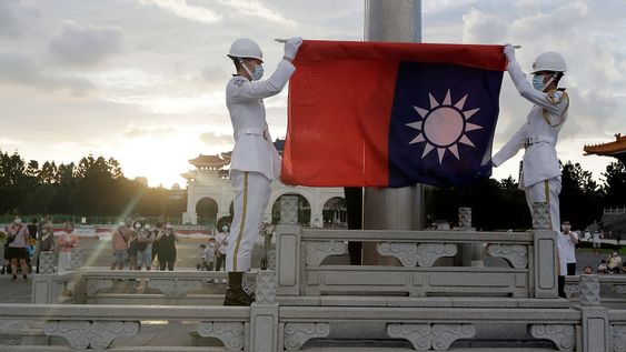 ARCHIVO - Dos soldados doblan la bandera nacional durante la ceremonia diaria de izado de bandera en la plaza Liberty en Taipéi, Taiwán, el 30 de julio de 2022. Taiwán dijo el lunes que seis globos chinos pasaron o bien sobre su isla o por el espacio aéreo justo al norte, y también se detectaron aviones y barcos militares chinos en la zona. (AP Foto/Chiang Ying-ying, Archivo)