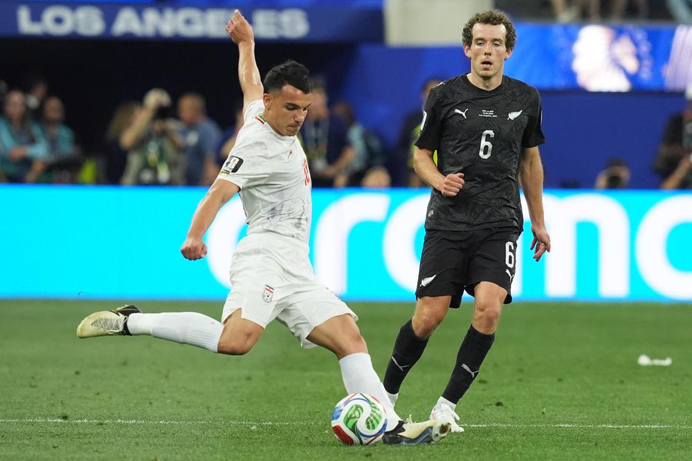 Amirhossein Hosseinzadeh (i) de Irán disputa un balón con Joe Bell de Nueva Zelanda este lunes, durante un partido del grupo G del Mundial de la FIFA 2026 entre Irán y Nueva Zelanda en el estadio SoFi en Los Ángeles (Estados Unidos).   