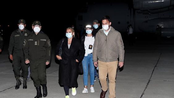 La ex presidenta interina de Bolivia, Jeanine Anez, centro, es escoltada por el ministro de gobierno Carlos Eduardo Del Castillo, derecha, y el comandante de la policía boliviana Jhonny Aguilera, izquierda. AP