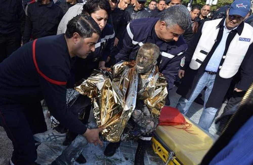 Varios peatones intentan ayudar a un hombre, después de que este se prendiera fuego, en el centro de Túnez. Gentileza / rfi