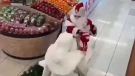 Dos Papá Noel a las piñas en un supermercado.