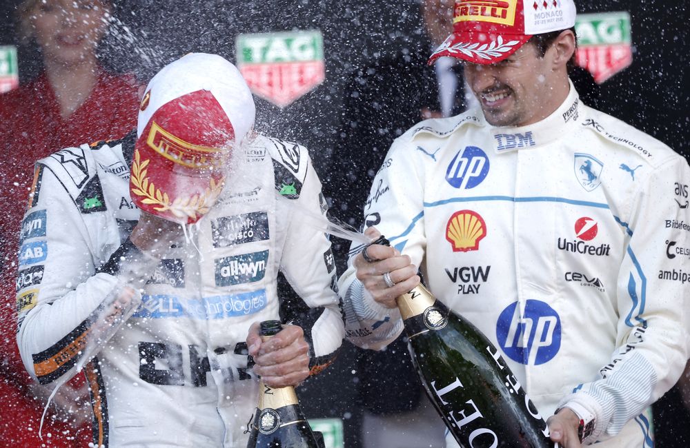 Lando Norris (izq.) es rociado con champ&aacute;n por el piloto de la Scuderia Ferrari, Charles Leclerc, de M&oacute;naco. Foto: EFE/EPA/YOAN VALAT