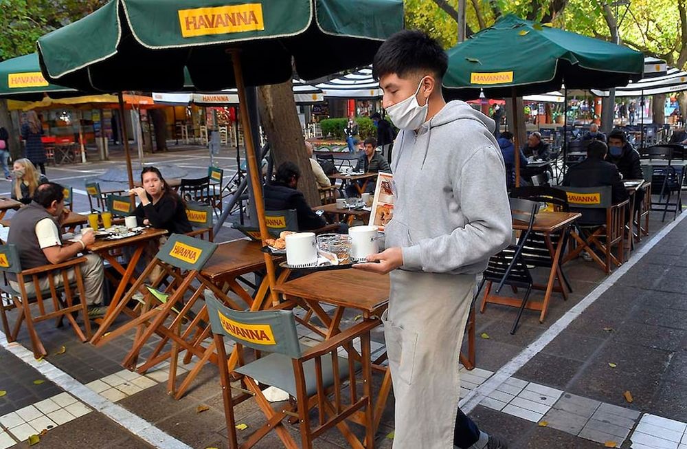 Desde hoy autorizan a Bares y Cafes a abrir sus puertas, y a atender a sus clientes, siguiendo el protocolo contra el Coronavirus.En la foto los empleados de cafes de la Peatonal Sarmiento acomodan y distancias las sillas y mesas a primera hora