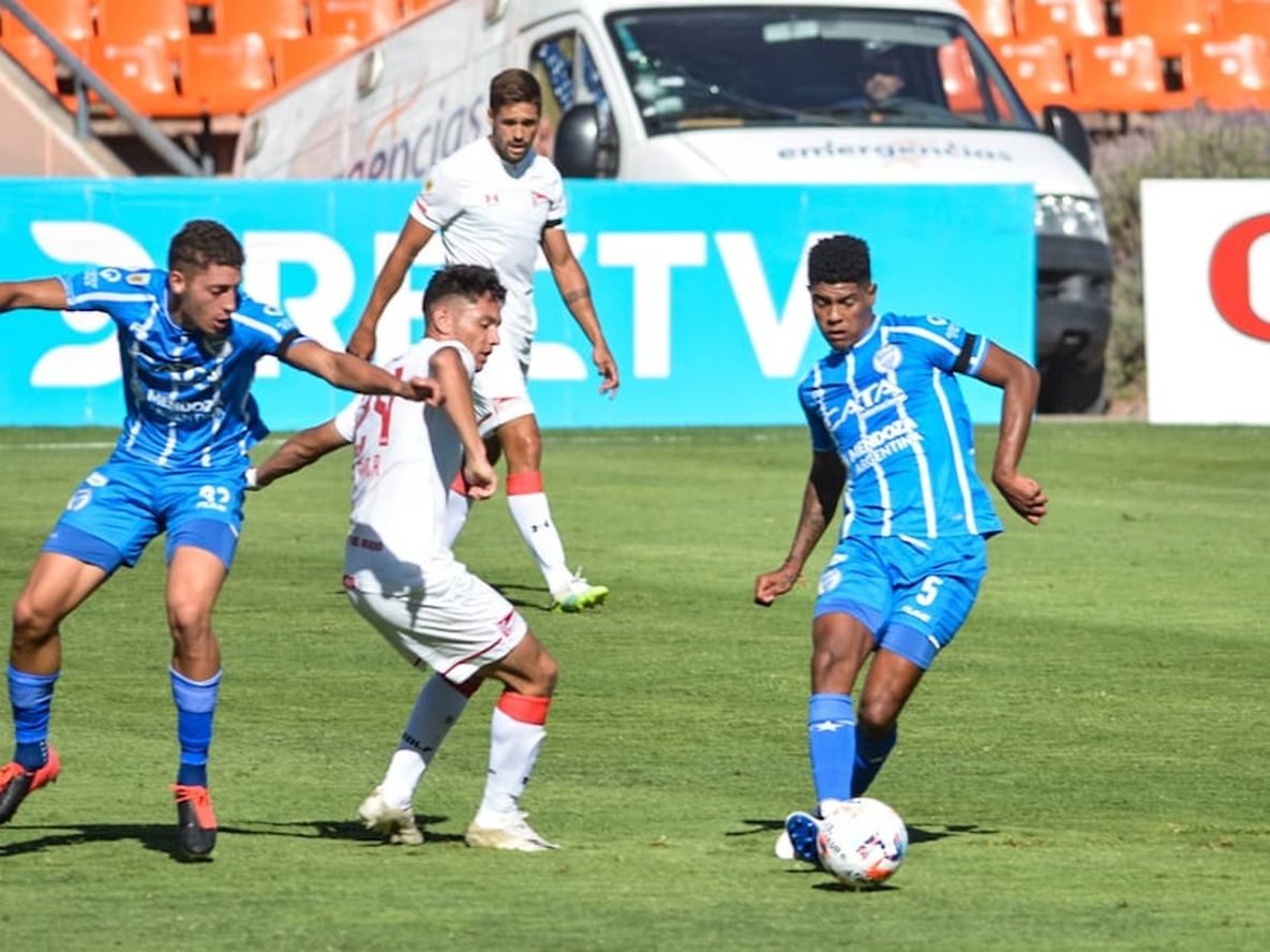 Wilder Cartagena hace un pase con cara interna, mientras Ábrego intenta frenar a Ayala, de Estudiantes. / Nicolás Ríos (Los Andes).
