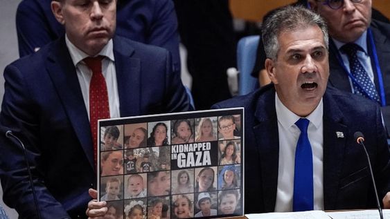 El ministro de Relaciones Exteriores de Israel, Eli Cohen, mostrando imágenes de los civiles secuestrados por Hamas ante el Consejo de Seguridad de la ONU mientras reclama al Secretario General, Antonio Guterres, por justificar a Hamas.