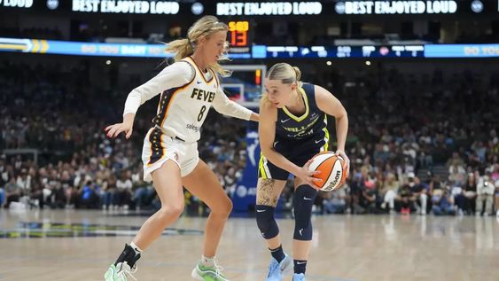 Polideportivo. Paige Bueckers (derecha) del Dallas Wings domina el balón ante la marca de Sophie Cunningham del Indiana Fever en el partido de la WNBA. Hace un tiempo que los hinchas lanzan juguetes a las jugadoras en partidos de la WNBA.