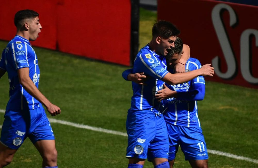 En crecimiento. Martín Ojeda acaba de cambiar penal por el 1-0 parcial y recibe el efusivo abrazo de Badaloni y Ábrego. El Tomba cree. / Mariana Villa / Los Andes.