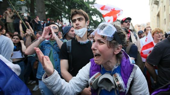 Una manifestante discute con policías durante una protesta opositora contra una ley sobre influencia extranjera ante el edificio del Parlamento en Tiflis, Georgia, el martes 28 de mayo de 2024. (AP Foto/Zurab Tsertsvadze)