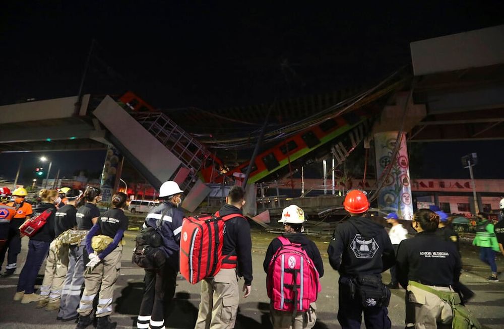 El personal de rescate se detiene frente a los vagones del metro de Ciudad de México tras el derrumbe del puente (AP)